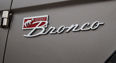 Classic Ford Bronco chrome emblem with sport badge on silver vehicle body panel