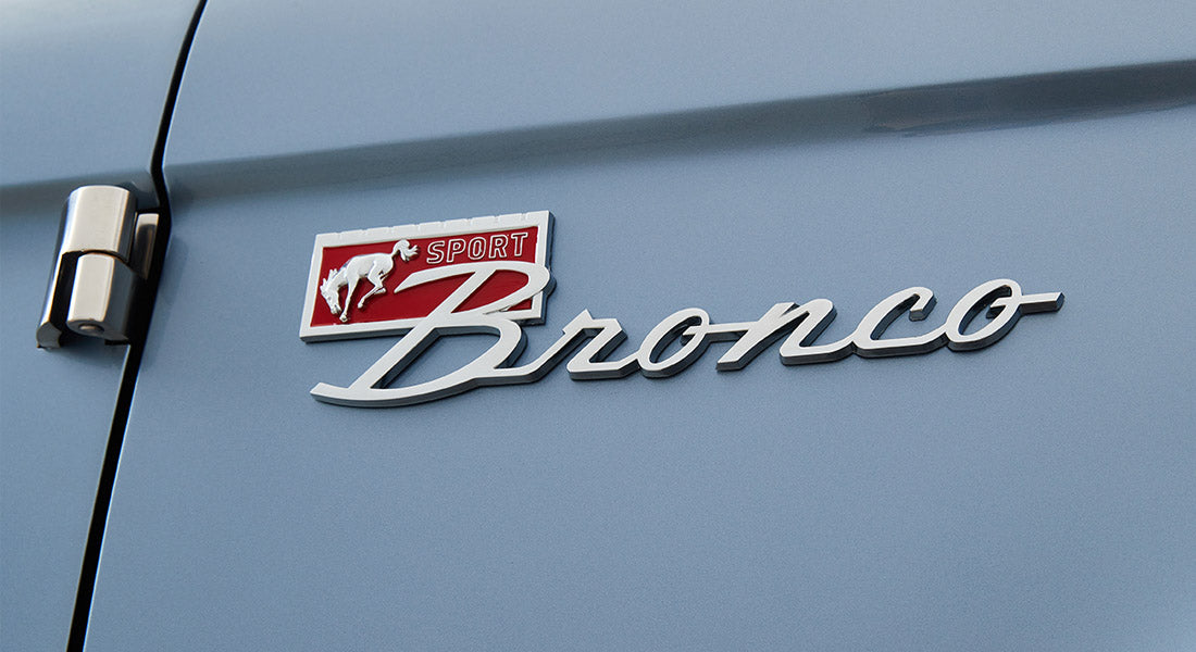 Silver Classic Ford Bronco Sport emblem on light blue vehicle door