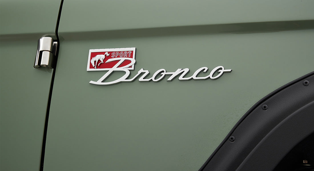 Metal Classic Ford Bronco Sport emblem on green vehicle door
