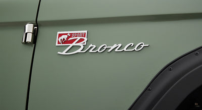 Metal Classic Ford Bronco Sport emblem on green vehicle door