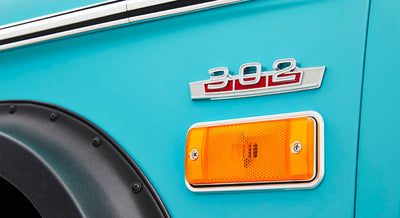 Aqua blue vehicle side panel showing silver 302 badge above amber side marker light