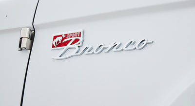 Classic Ford Bronco emblem on white vehicle door with small horse logo and SPORT text