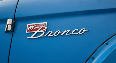 Blue Classic Ford Bronco door panel with Sport Bronco emblem near hinge