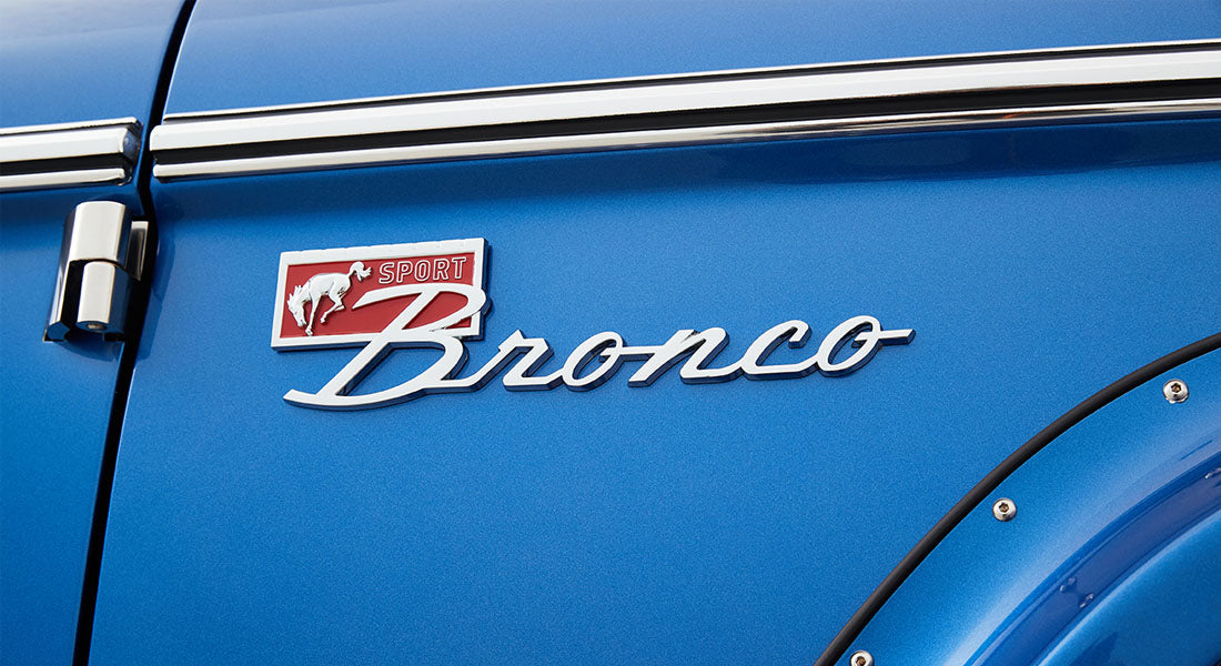 Chrome Sport Bronco emblem on a blue vehicle door