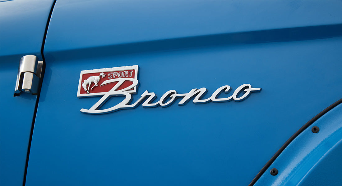 1976 Blue Classic Ford Bronco Coyote Series with black soft top and whiskey leather interior