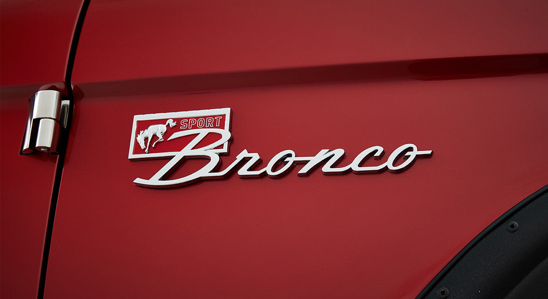 Red door panel with chrome Classic Ford Bronco Sport emblem and silver door hinge