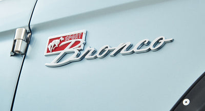 Classic Ford Bronco chrome 'Sport Bronco' emblem on light blue vehicle door