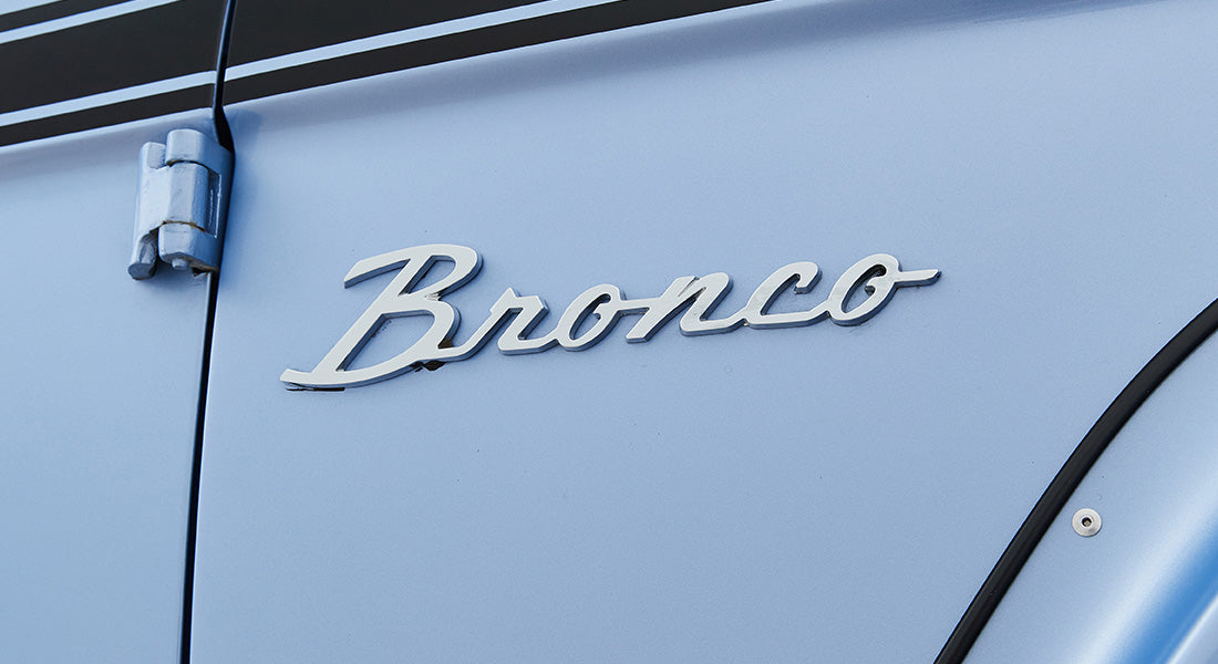 Close-up of Classic Ford Bronco emblem on light blue vehicle door