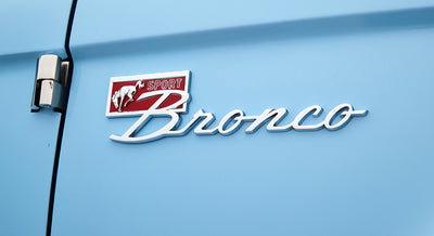 Close-up of Classic Ford Bronco Sport emblem on light blue vehicle body