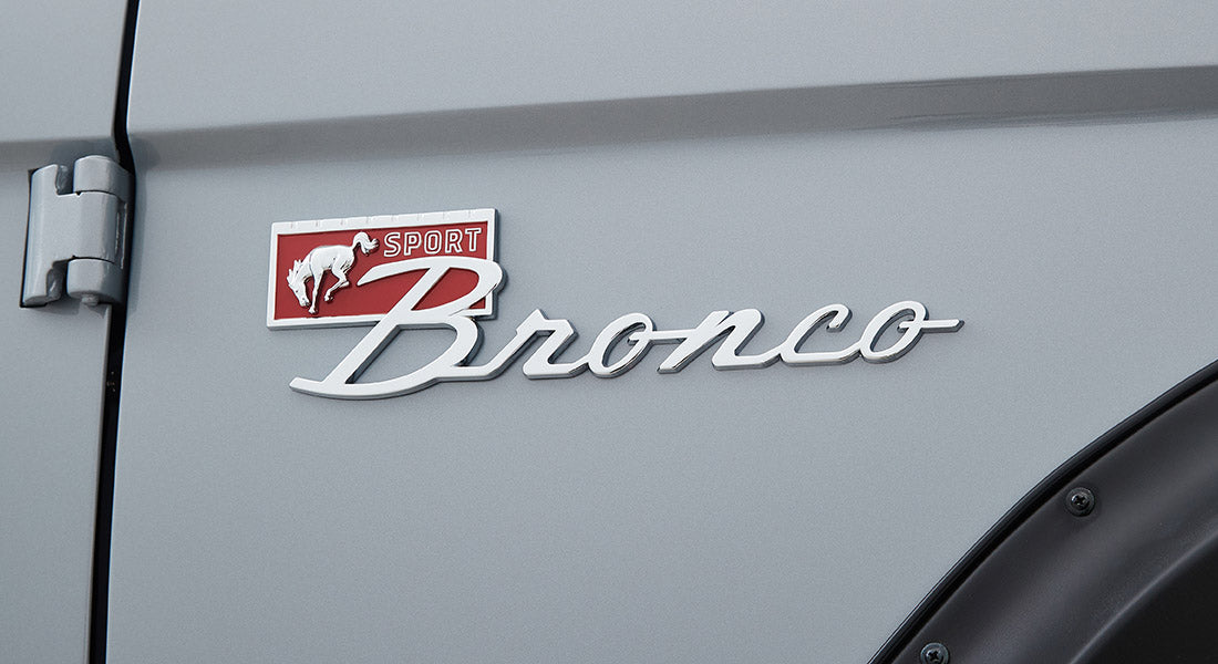 Close-up of Classic Ford Bronco emblem with red and white colors on light gray body
