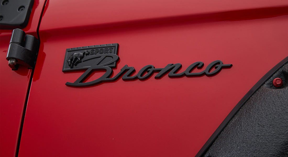 Glossy red door panel featuring black Sport Bronco emblem on Classic Ford Bronco
