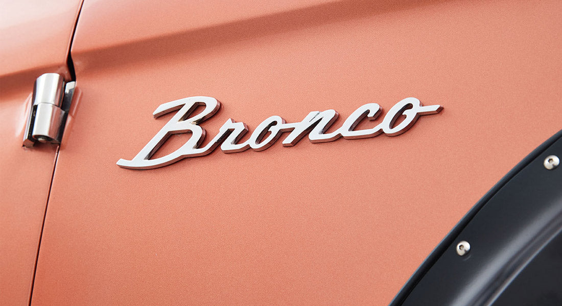 Chrome Classic Ford Bronco emblem mounted on an orange body panel