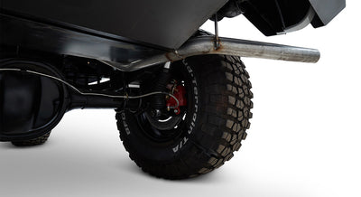 Rear suspension and exhaust pipe visible beneath Classic Ford Bronco with large tires