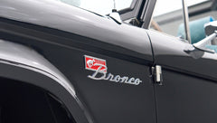 Side close-up of black Classic Ford Bronco with red and chrome Bronco badge