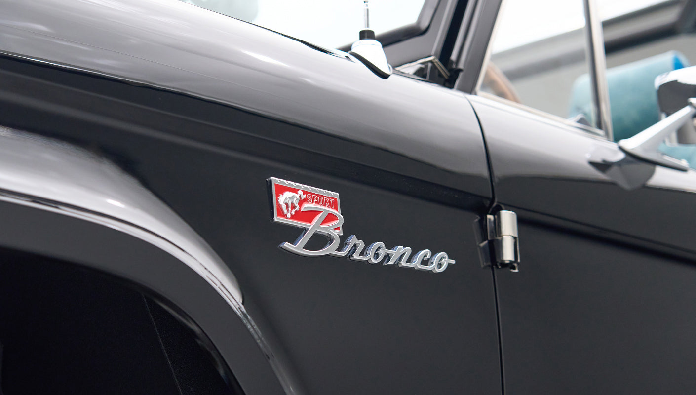 Side close-up of black Classic Ford Bronco with red and chrome Bronco badge