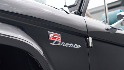 Side close-up of black Classic Ford Bronco with red and chrome Bronco badge