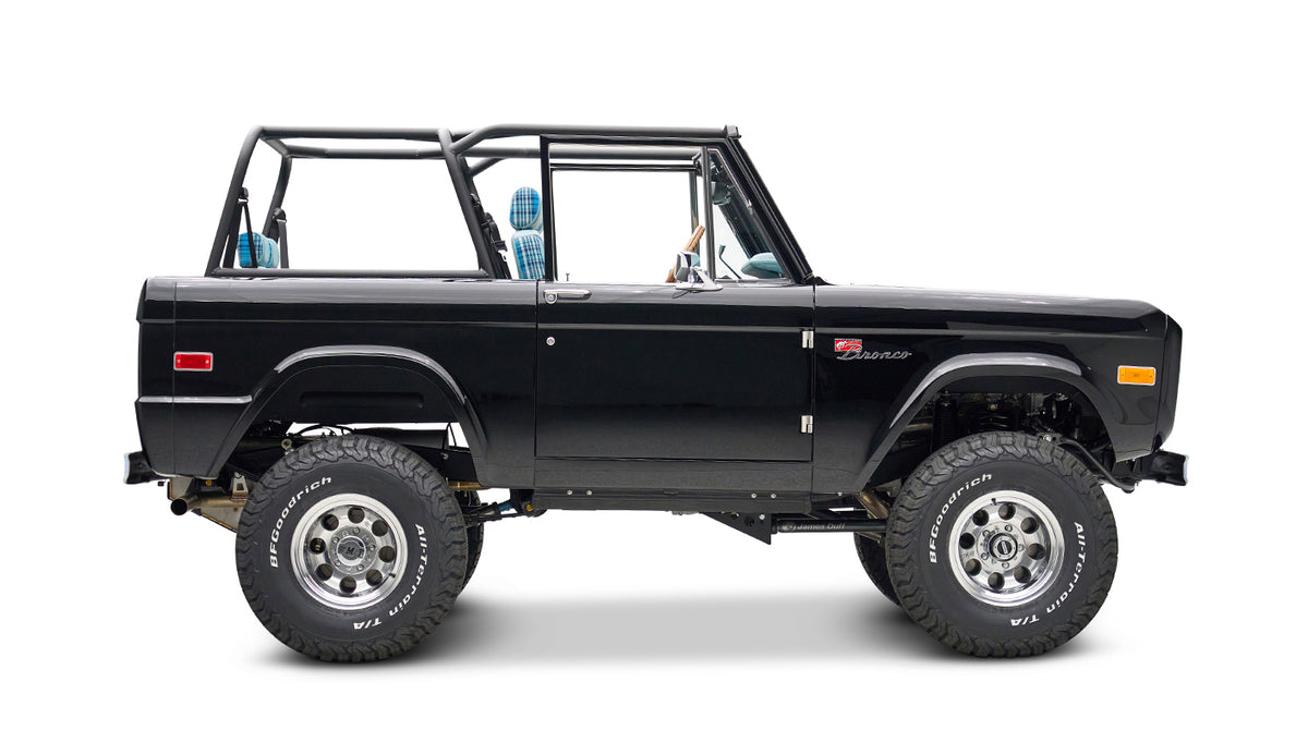 Side profile of black Classic Ford Bronco with lifted suspension and plaid seats