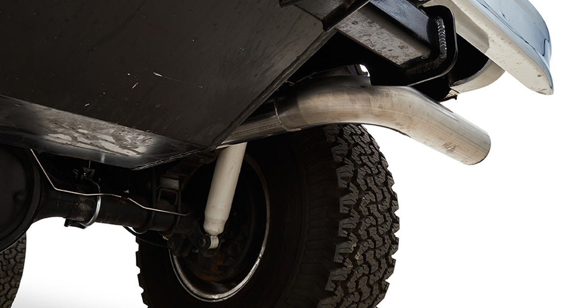 Underneath view of Classic Ford Bronco showing rear tire and chrome exhaust pipe
