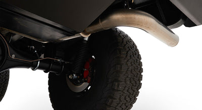 Rear suspension, tire, and exhaust pipe visible under Classic Ford Bronco vehicle