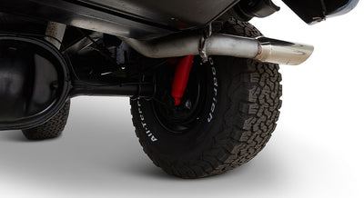 Rear tire, red shock absorber, and exhaust pipe of a Classic Ford Bronco