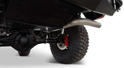 View of rear underside of Classic Ford Bronco showing large tire, axle, and exhaust pipe