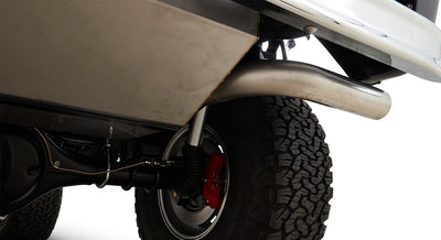 Rear suspension view with red brake caliper, exhaust pipe, and large off-road tire