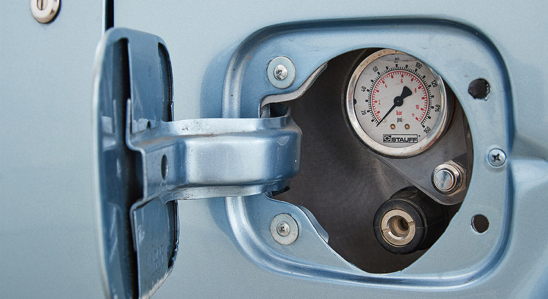 Fuel filler door open showing pressure gauge and filler port on Classic Ford Bronco