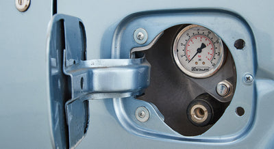 Fuel filler door open showing pressure gauge and filler port on Classic Ford Bronco