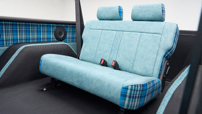 Rear seat inside Classic Ford Bronco upholstered in blue plaid and leather