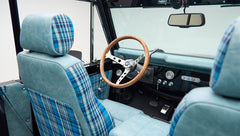 Interior front seats and dashboard with wooden steering wheel inside Classic Ford Bronco