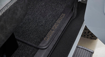 Interior floormat with 'CLASSIC FORD BRONCOS' text visible on dark carpeted surface