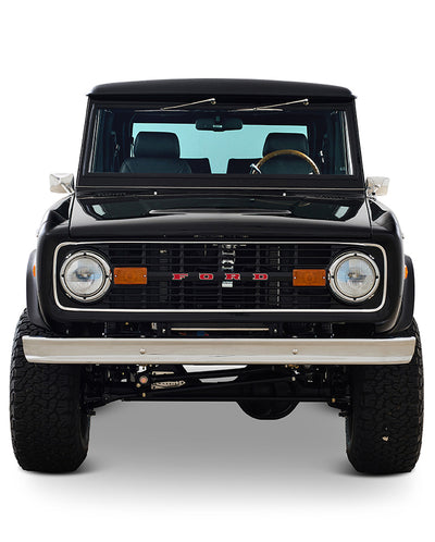 Front view of a classic black Ford Bronco with black interior and brown steering wheel