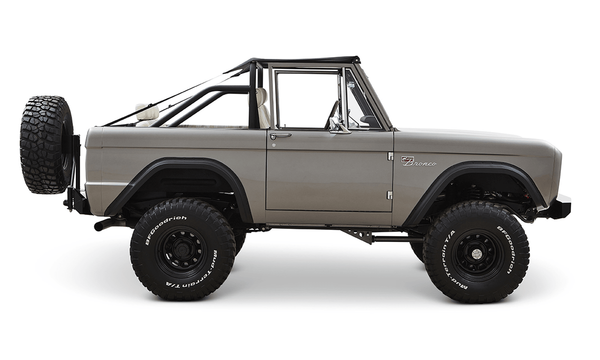 Classic Ford Bronco in matte silver side view with black trim and white interior