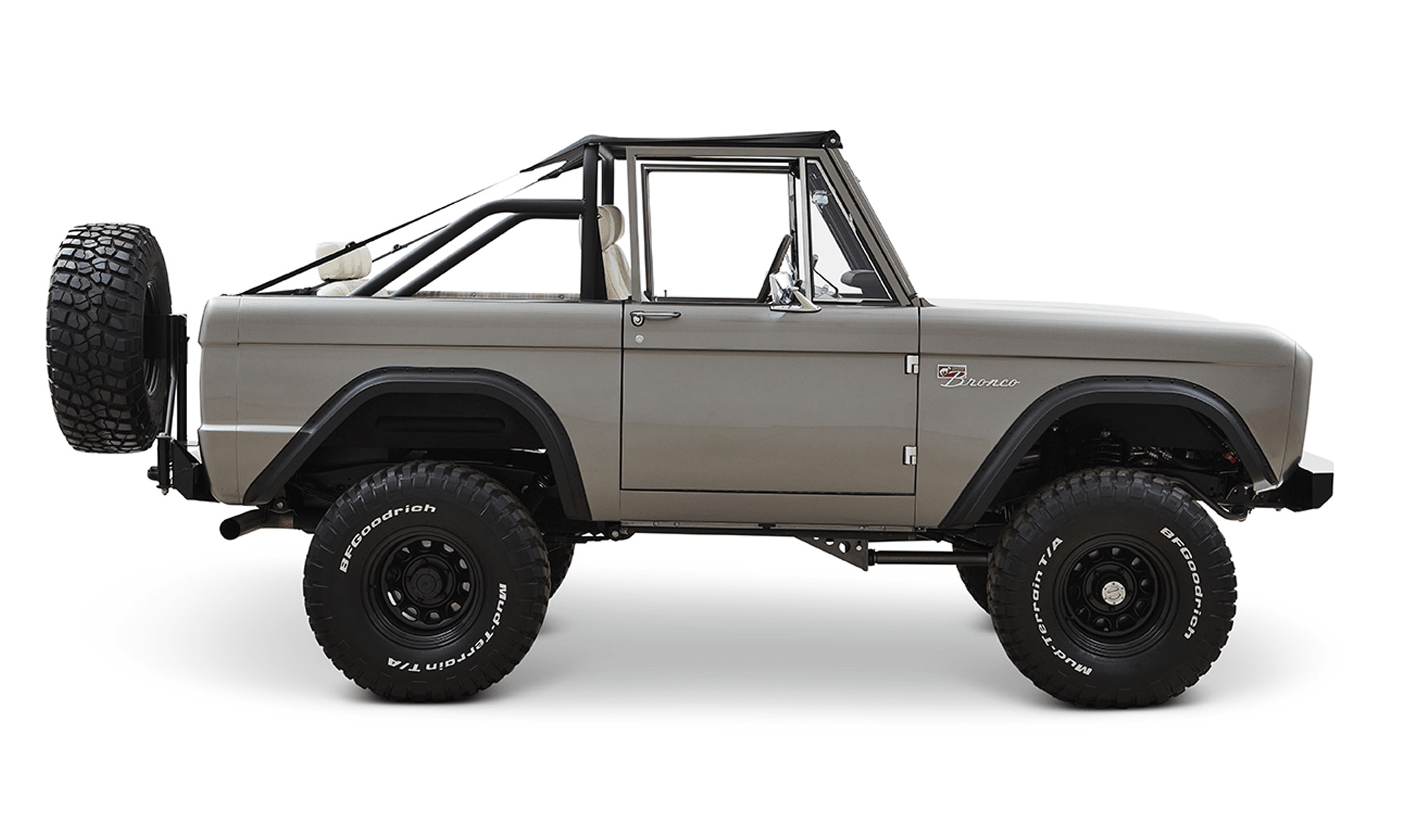 Classic Ford Bronco in matte silver side view with black trim and white interior