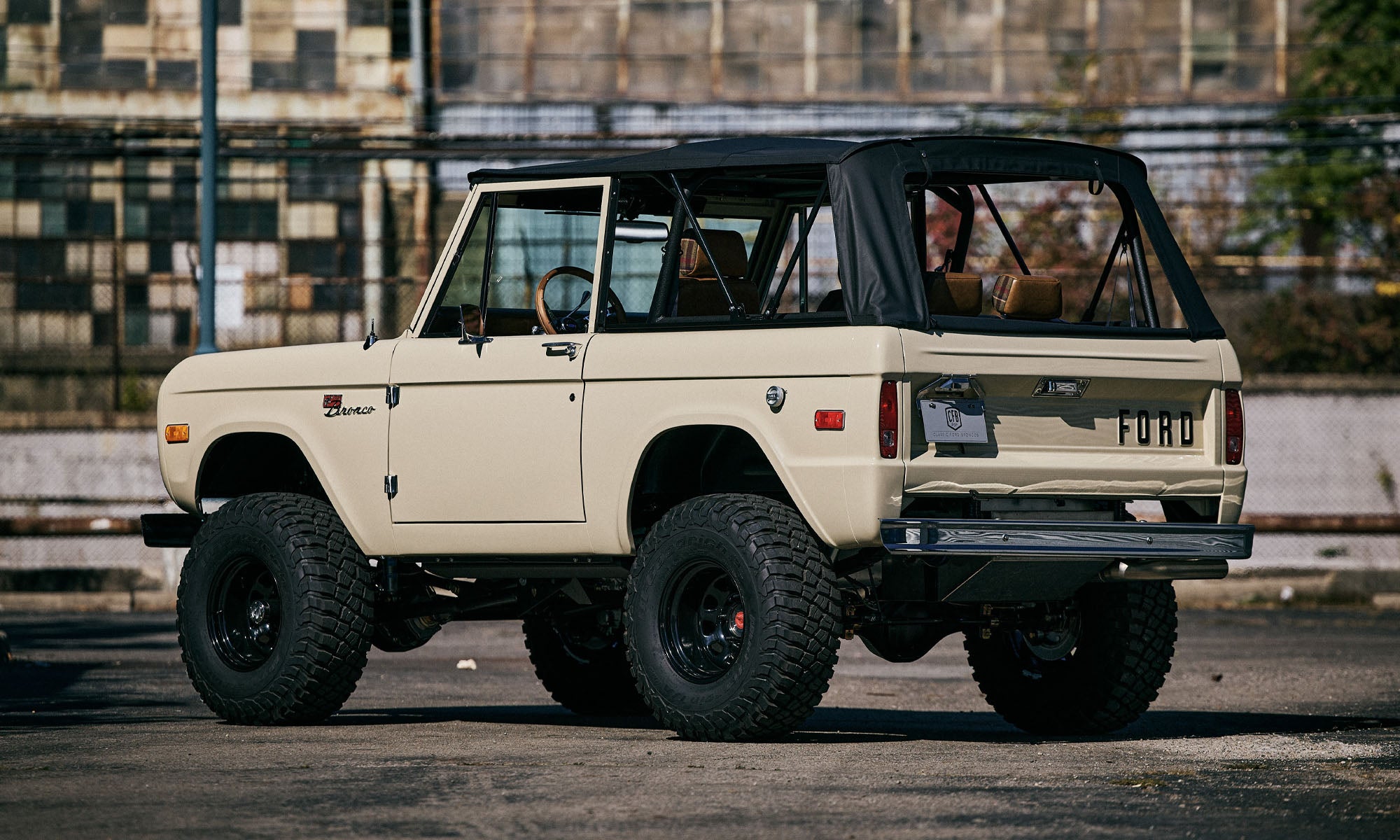 Front three-quarter view of Classic Ford Bronco 1971 Quicksand with black soft top and black wheels