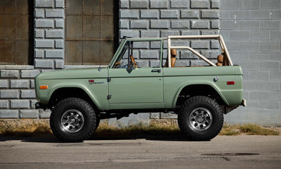 Classic Ford Bronco in grasmere green with black roll cage seen from driver side