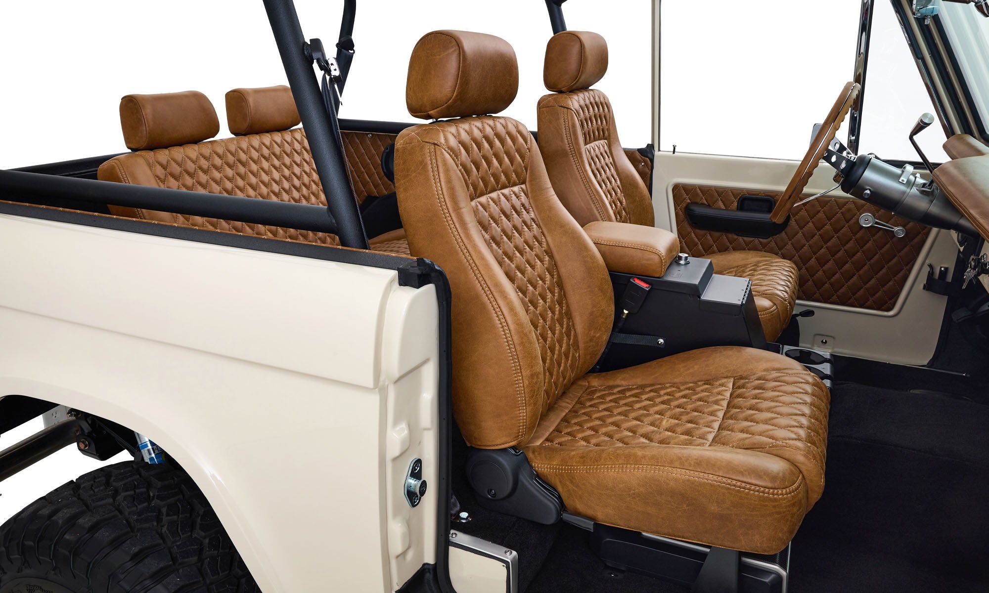 Passenger interior of Classic Ford Bronco with cream exterior and tan quilted leather seats