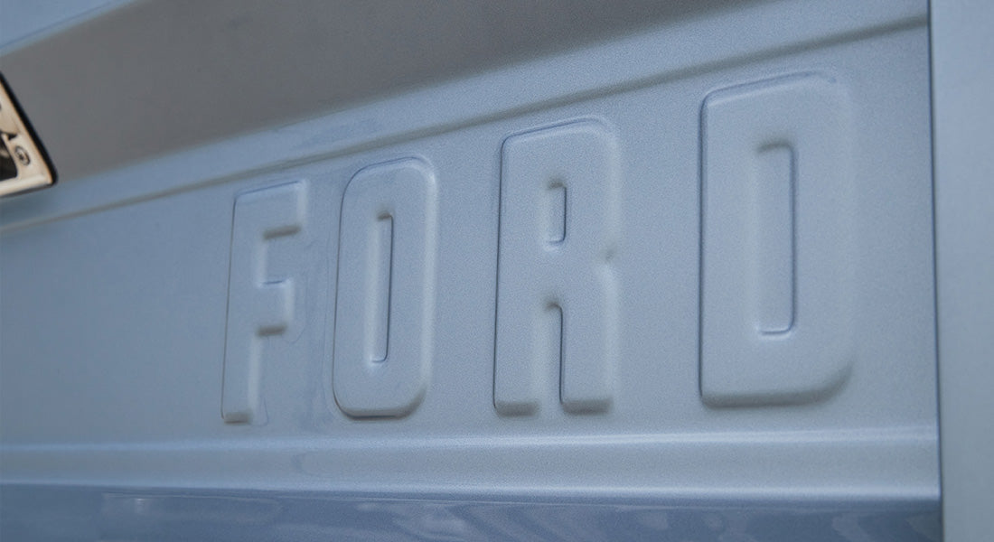 Embossed 'FORD' lettering on light blue vehicle body panel