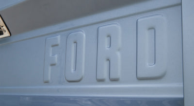 Embossed 'FORD' lettering on light blue vehicle body panel