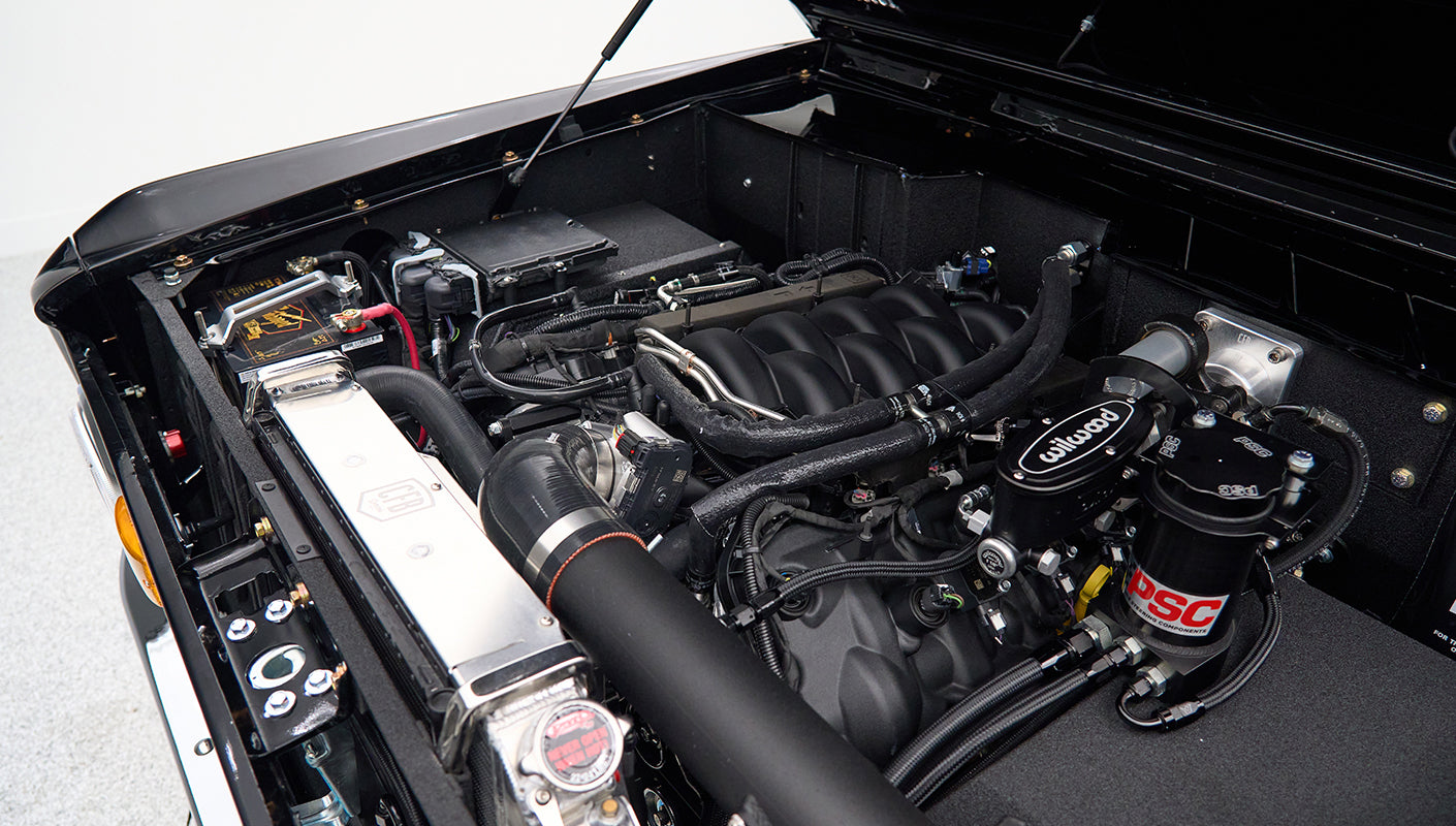 Detailed view of Classic Ford Bronco engine compartment with modern components and polished radiator