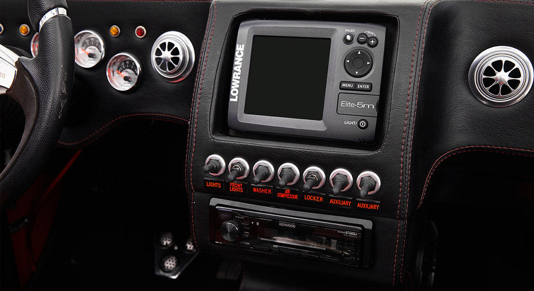 Dashboard of Classic Ford Bronco featuring switches, digital device, and Kenwood stereo unit.