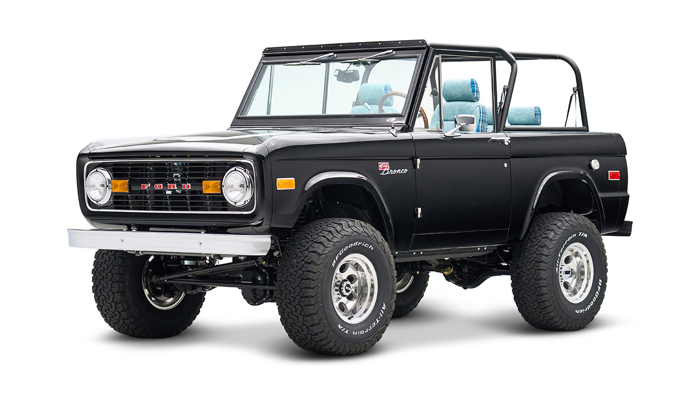 Front three-quarter view of black Classic Ford Bronco with roll cage and off-road tires