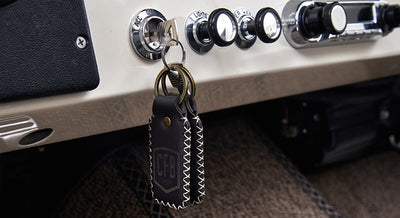 Ignition switch with keys attached to leather keychains hanging from Classic Ford Bronco dashboard
