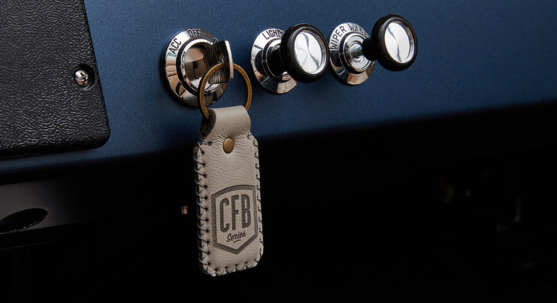 Leather keychain with CFB Series logo hanging from a classic vehicle ignition