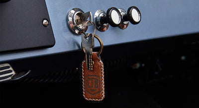 Car keys with leather keychain inserted in ignition of Classic Ford Bronco dashboard