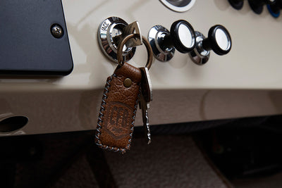 Close-up of ignition switch with leather keychain and metal key in Classic Ford Bronco dashboard
