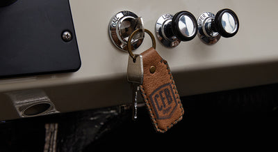 Leather keychain with JCR logo hanging from ignition in Classic Ford Bronco dashboard