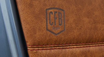 Brown leather surface with stamped CFB logo and red stitching detail