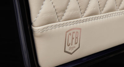 Close-up of white quilted leather upholstery panel with printed CFB Series logo