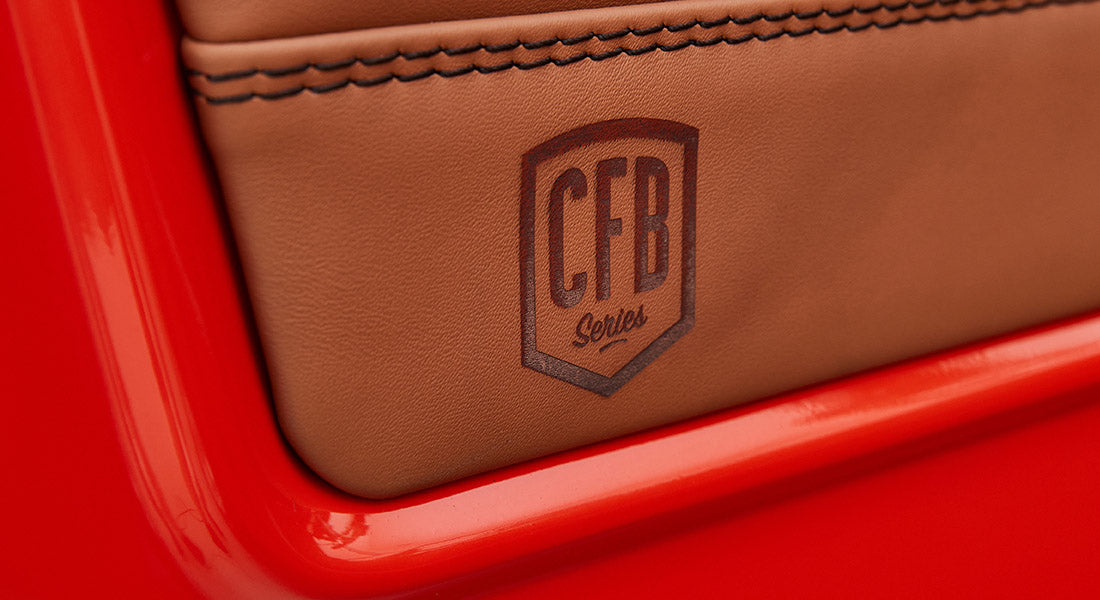 Red Classic Ford Bronco door panel with silver 'Sport Bronco' emblem